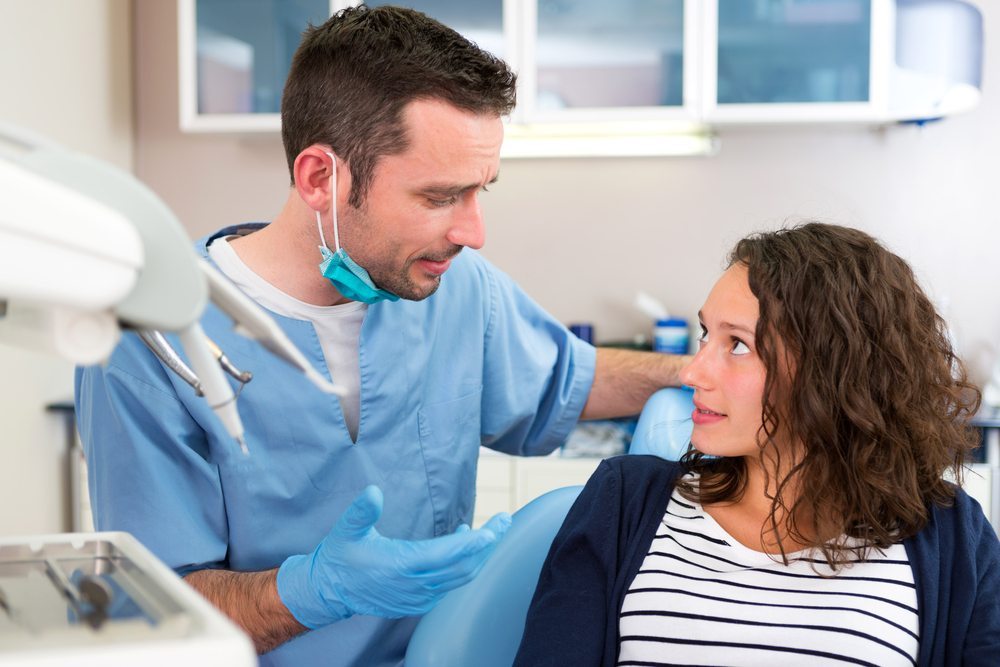 Dentist talking with his patient about non surgical dental treatment